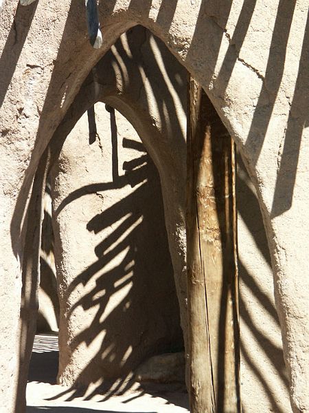 DoorPICT4655-w.jpg - #0111_Adobe Door:  African doorway made of mud and wood in the Albuquerque Zoo, New Mexico.  I liked the play of patterns made by the shadows on the walls.